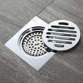 Rejilla desagüe ducha de acero inoxidable 10x10 cm con marco para instalación en piso de baño moderno.