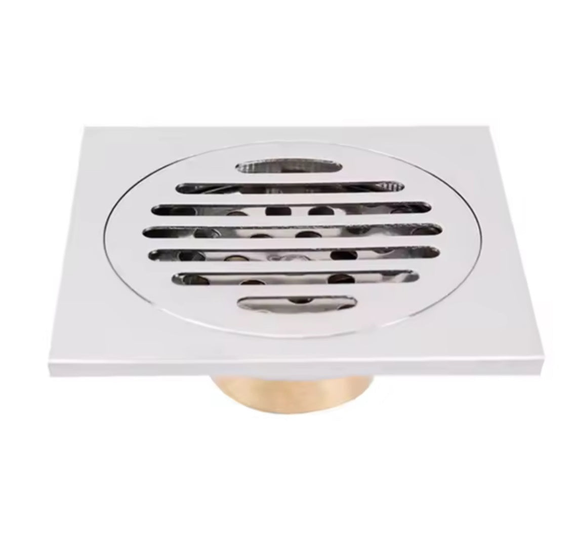 Rejilla desagüe ducha de acero inoxidable 10x10 cm con marco para instalación en piso de baño moderno.